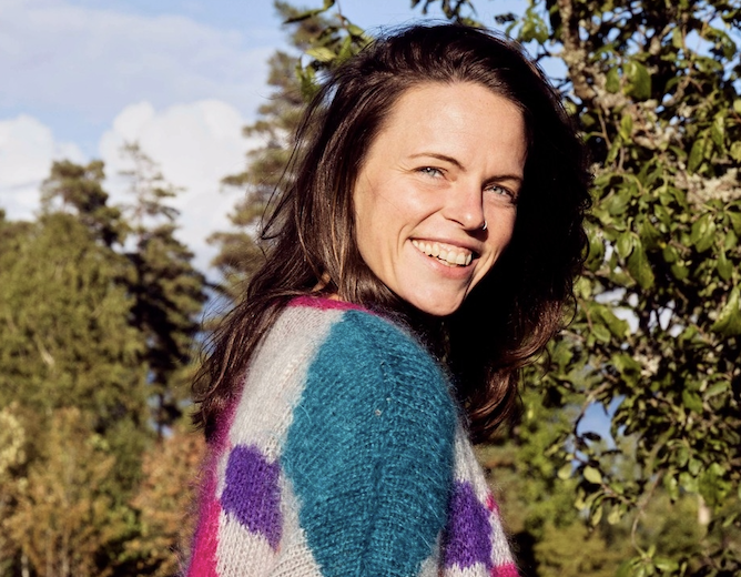 Sandra Calabria Geitz smiling outdoors in a colourful sweater